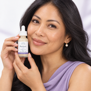 Filipina woman in her late thirties holding Illuminate YOU tone serum