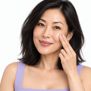 East Asian woman applying clear Refine YOU niacinamide serum to her cheek